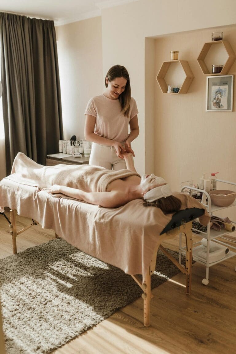 A serene spa setting with a woman receiving a relaxing massage session for ultimate wellness.