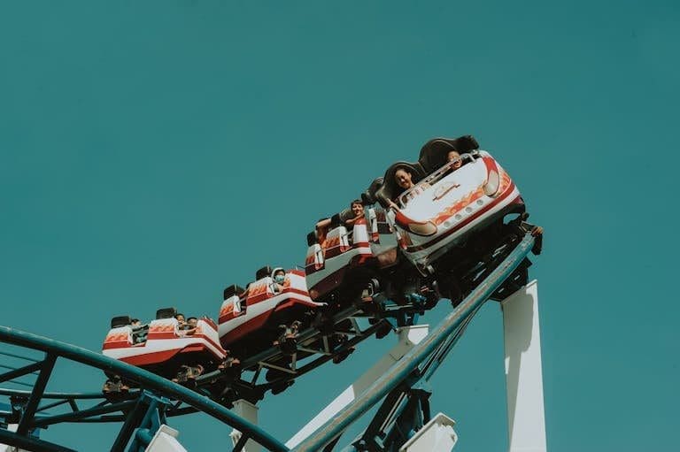 A group of people enjoying a thrilling roller coaster ride at an amusement park.