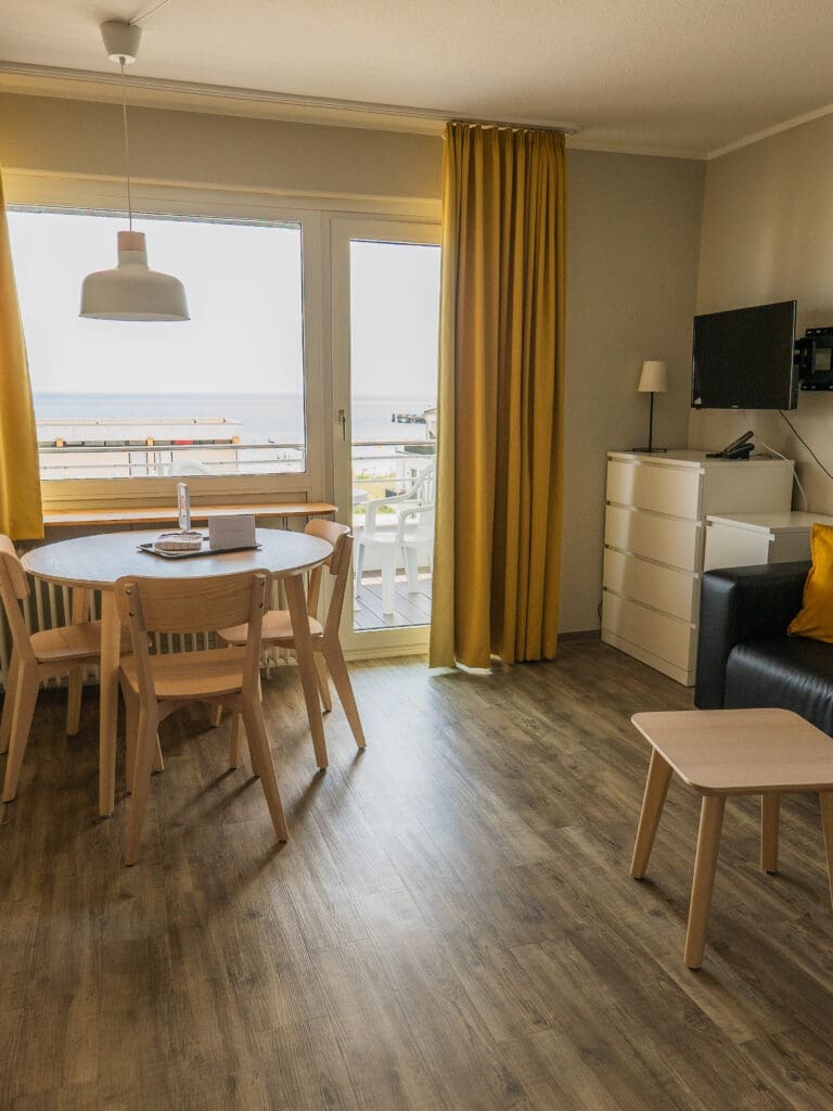 Zimmer mit Esstisch, Fenster und Vorhängen